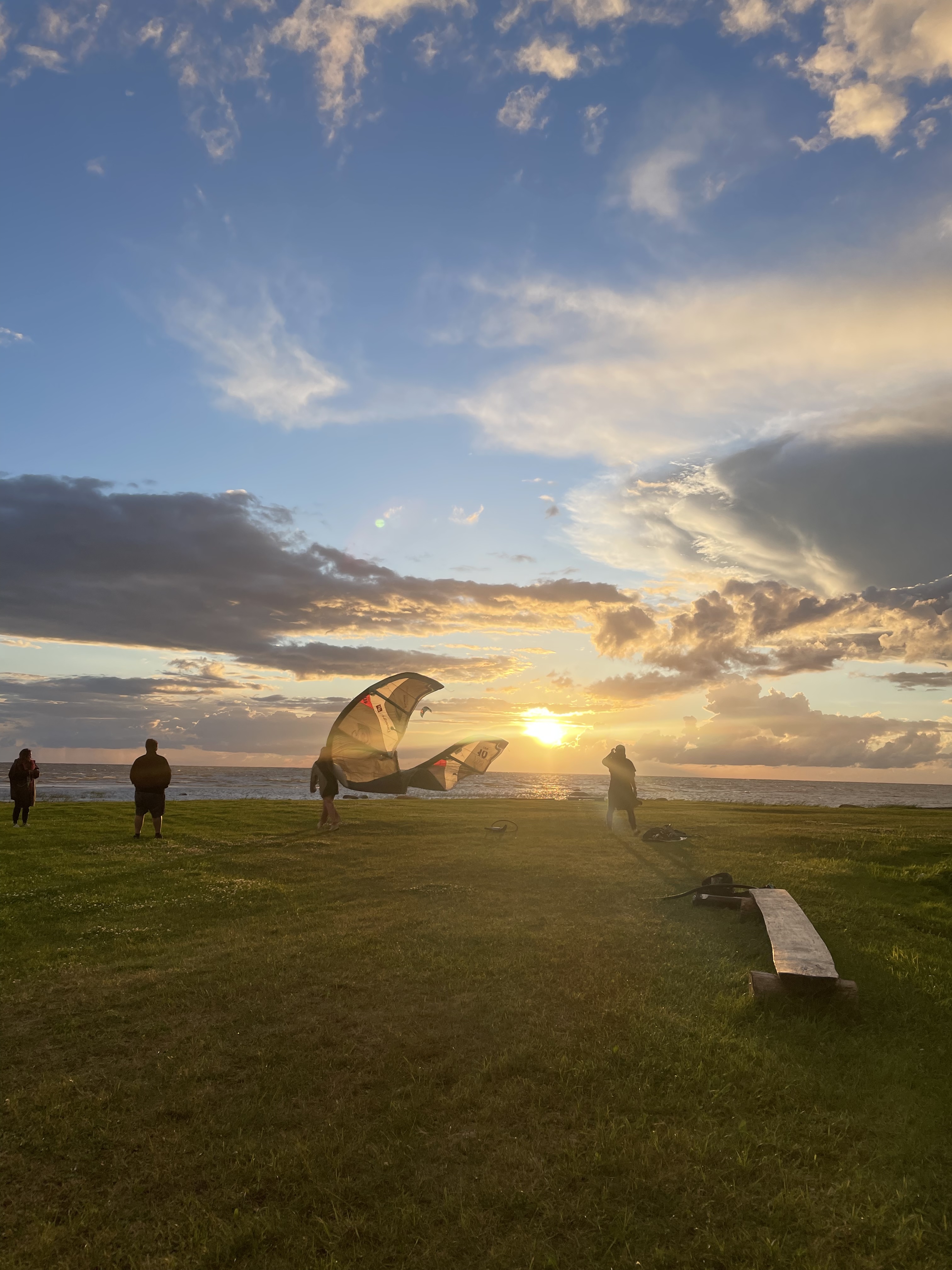 Kitesurfers rigging a kite on an Estonian coast at sunset